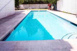 una piscina de agua azul en una casa en Howard Johnson by Wyndham Spokane en Spokane