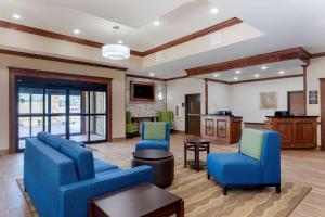 a living room with two blue chairs and a table at Comfort Suites West Monroe near Ike Hamilton Expo Center in West Monroe