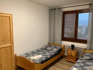 1 dormitorio con 2 camas y ventana en Ubytování u koupaliště, en Velké Meziříčí