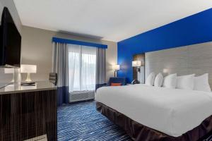 Habitación de hotel con cama grande y ventana grande. en Comfort Inn & Suites, en Memphis