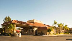 a hotel with a building with palm trees at Studio 6 Anaheim Hills CA in Anaheim
