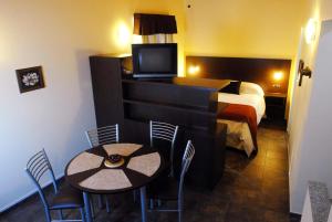 Habitación de hotel con cama, mesa y sillas en Complejo Barraquero en Mendoza