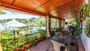 a patio with a table and chairs and a pool at Casa El Olivarito Jubrique by Ruralidays in Jubrique
