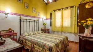 a bedroom with a bed in a room with yellow walls at Casa El Olivarito Jubrique by Ruralidays in Jubrique +15 photos