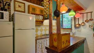 a kitchen with a white refrigerator and a clock at Casa El Olivarito Jubrique by Ruralidays in Jubrique