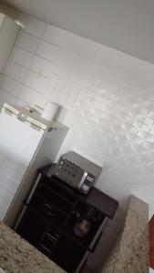 a room with a white tiled wall and a table at D frente Green D 3 in Vila Velha