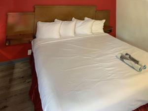 - un grand lit blanc avec deux remorques dans l'établissement Rodeway Inn, à Augusta