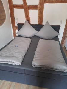 uma cama com duas almofadas em cima em Gästehaus Leonie em Ebrach