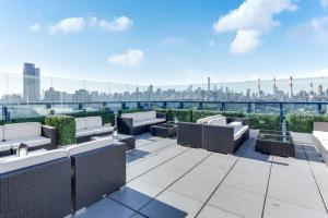 a rooftop patio with couches and a view of the city at Vista LIC Hotel, Premier Collection by Best Western in Queens