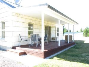 um deque com cadeiras e uma mesa numa casa em Gladstone Cottage em Twizel