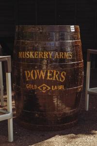 a wooden barrel with a sign on the side of it at Muskerry Arms Bar and B&B in Blarney
