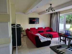 un soggiorno con divano rosso e TV di Casa Pablo a Jablonna