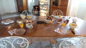 una mesa de madera con comida y bebidas. en Chambre d'hôtes LES LOUVES, en Saint-Paul-des-Fonts