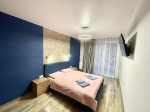 ein Schlafzimmer mit einem Bett und einer blauen Wand in der Unterkunft Resident Hall in Lwiw