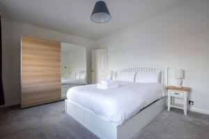 a white bedroom with a white bed and a mirror at Contemporary Home in Friendly Easton, Free Parking in Bristol