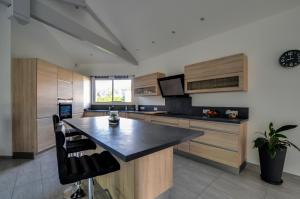 a kitchen with wooden cabinets and a black counter top at BISCADODO, joignable au zéro6trente53cinquante60 in Biscarrosse