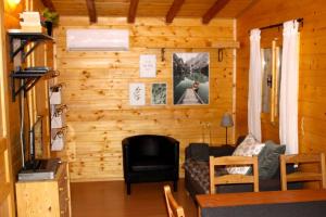 - un salon avec un mur en bois dans l'établissement Te huur: 5 persoons chalet aan het Luganomeer, à Porlezza