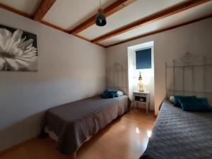 een slaapkamer met 2 bedden en een raam bij Chambre d'hôtes LES LOUVES in Saint-Paul-des-Fonts