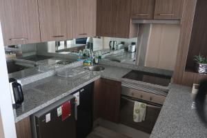 a kitchen with wooden cabinets and granite counter tops at Hermoso departamento, excelente ubicación in Santiago