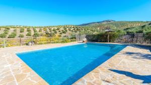 ein blauer Pool mit einem Berg im Hintergrund in der Unterkunft Casa La Cabana Priego de Cordoba by Ruralidays in Priego de Córdoba