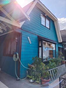ein blaues Haus mit einem Schlauch davor in der Unterkunft lotus shared-house in Puerto Montt