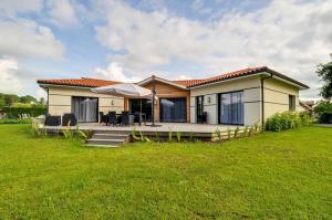 a small house with a green lawn in front of it at BISCADODO, joignable au zéro6trente53cinquante60 in Biscarrosse