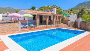 a swimming pool in front of a house at Cortijo Metomela Torrox by Ruralidays in Frigiliana