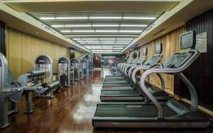 einen Fitnessraum mit einer Reihe von Laufbändern und Maschinen in der Unterkunft Tongquetai Jinling Hotel Tongling Anhui in Tongling