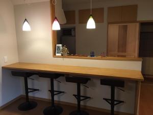 une cuisine avec un comptoir et des tabourets sous un miroir dans l'établissement Makotoya - Vacation STAY 69812v, à Takayama