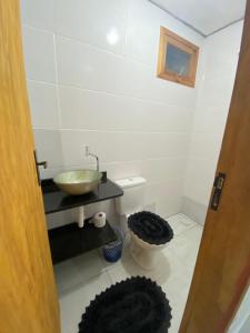 a bathroom with a sink and a toilet at Chalé Aconchego 1 in Ilhabela +7 photos