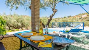 - une table avec des assiettes de nourriture à côté d'une piscine dans l'établissement Casa La Cuesta Competa by Ruralidays, à Cómpeta