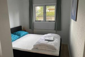 a small bedroom with a bed and a window at Modern rustgevend chalet in Putten 131 in Putten