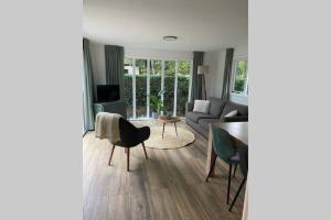 a living room with a table and a couch at Modern rustgevend chalet in Putten 131 in Putten