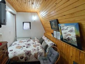 a small bedroom with a bed and a wooden ceiling at Apartments Panda in Vlasic