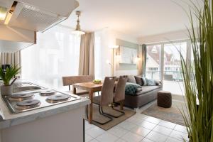 eine Küche und ein Wohnzimmer mit einem Sofa und einem Tisch in der Unterkunft Hansa-Residenz Kleine Oase Scharbeutz in Scharbeutz