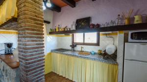 a kitchen with a counter with a sink and a refrigerator at Casa Jara de El Gastor by Ruralidays in El Gastor