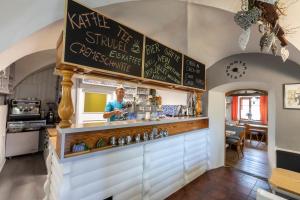 a man standing behind a counter in a kitchen at Gasthof Altes Hammerherrenhaus in Übelbach +81 photos