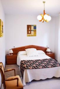 een slaapkamer met een bed en een stoel bij Vivienda vacacional El Bosque in Llovio