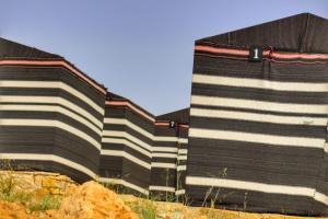 ein großes Gebäude mit schwarzen und weißen Streifen in der Unterkunft Ein lahda camp-site in Dana