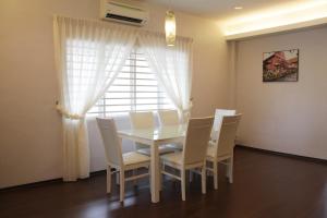 a dining room with a table and chairs and a window at My Sweet Home in Malacca