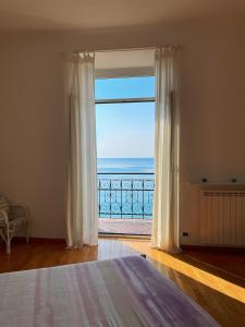 um quarto com uma janela com vista para o oceano em CasAmare di Carla em Savona