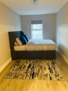 - un lit dans une chambre avec un tapis au sol dans l'établissement Luxurious Beach Front Apartment in Portrush, à Portrush