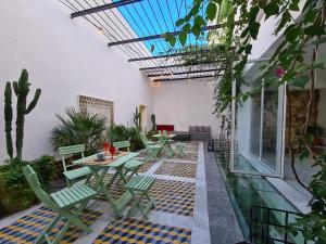 un patio al aire libre con mesas, sillas y plantas en Dar El Kif - La Marsa, en La Marsa