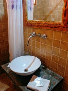 a bathroom with a sink and a mirror at Hostal Paseo de los Colorados in Purmamarca +26 photos