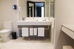a bathroom with a white sink and a toilet at Barceló Mexico Reforma in Mexico City