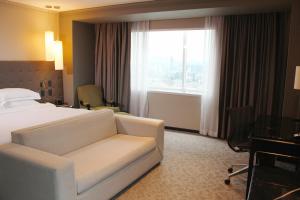 a hotel room with a bed and a couch and a window at Barceló Mexico Reforma in Mexico City