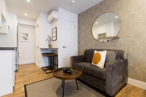 a living room with a couch and a mirror at Blue Oasis Studio with Full Kitchen and Bath by Den Stays in Montréal