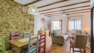 a living room with a table and a stone wall at Casa Los Bancales Cortes de la Frontera by Ruralidays in Cortes de la Frontera