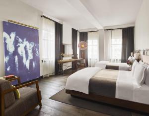 ニューヨークにあるリファイナリー ホテル ニューヨークのベッド2台とソファが備わるホテルルームです。