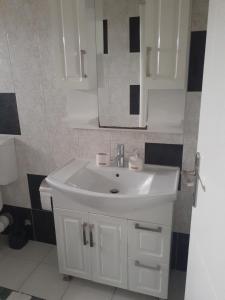 y baño con lavabo blanco y espejo. en Apartmani Irena, en Tivat